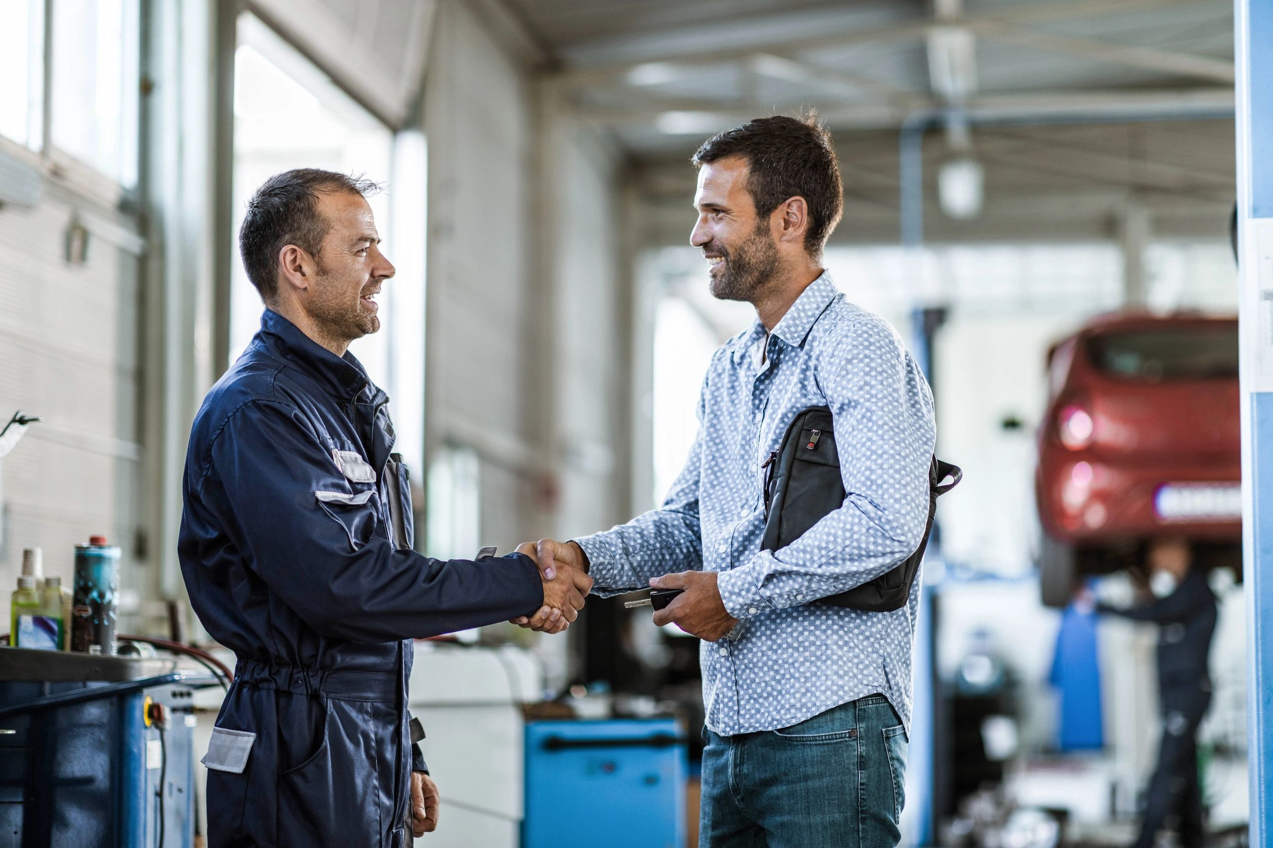 Customer shaking hands with a mechanic in an auto repair shop