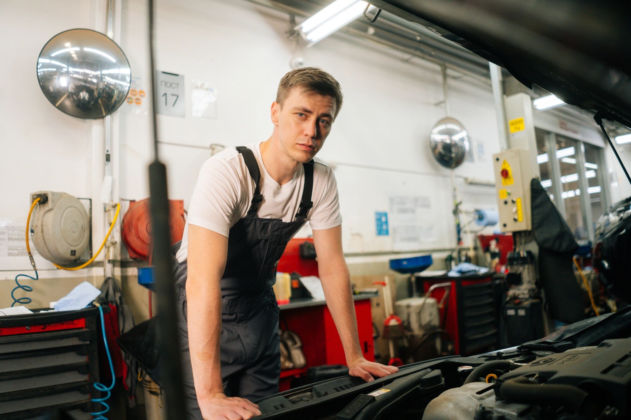 Professional mechanic inspecting a vehicle with the hood open