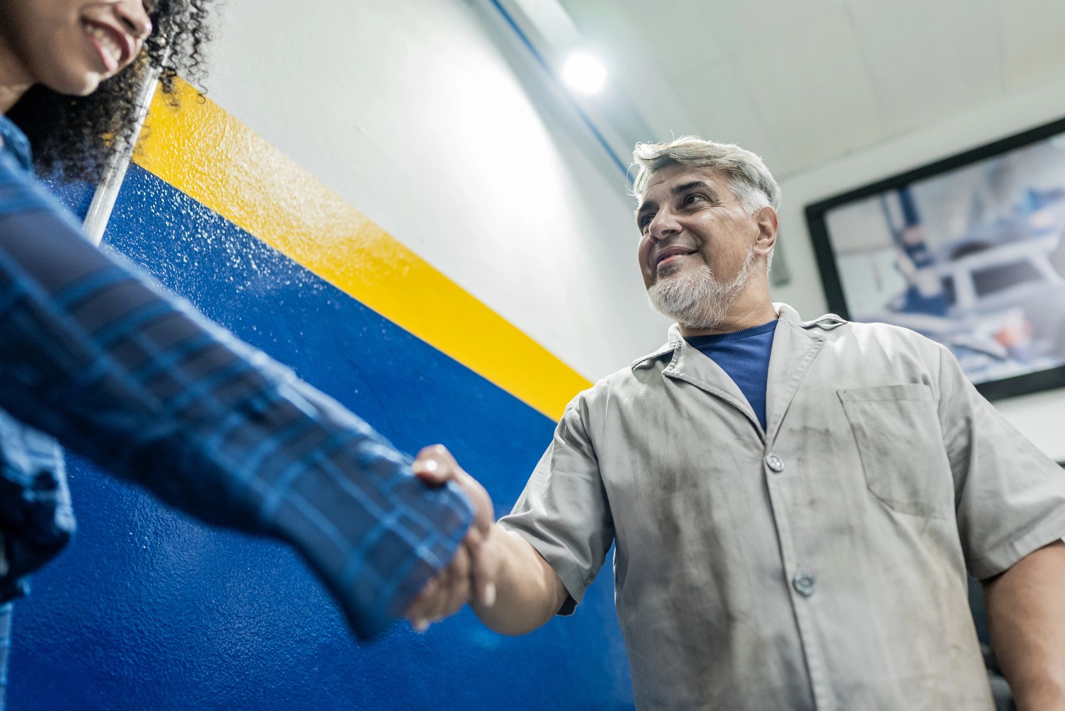 Customer speaking with an auto mechanic in a repair shop