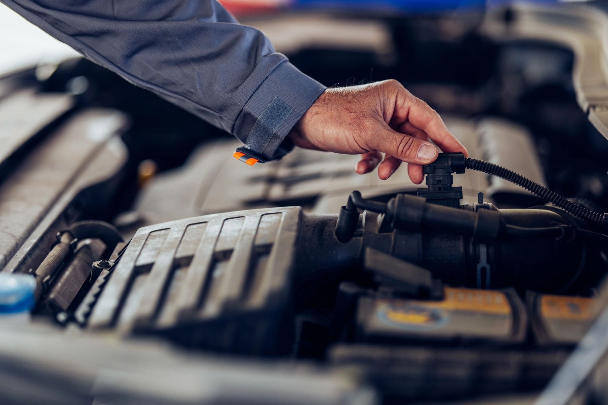 Close-up of a mechanic inspecting an engine bay during a tuning service.