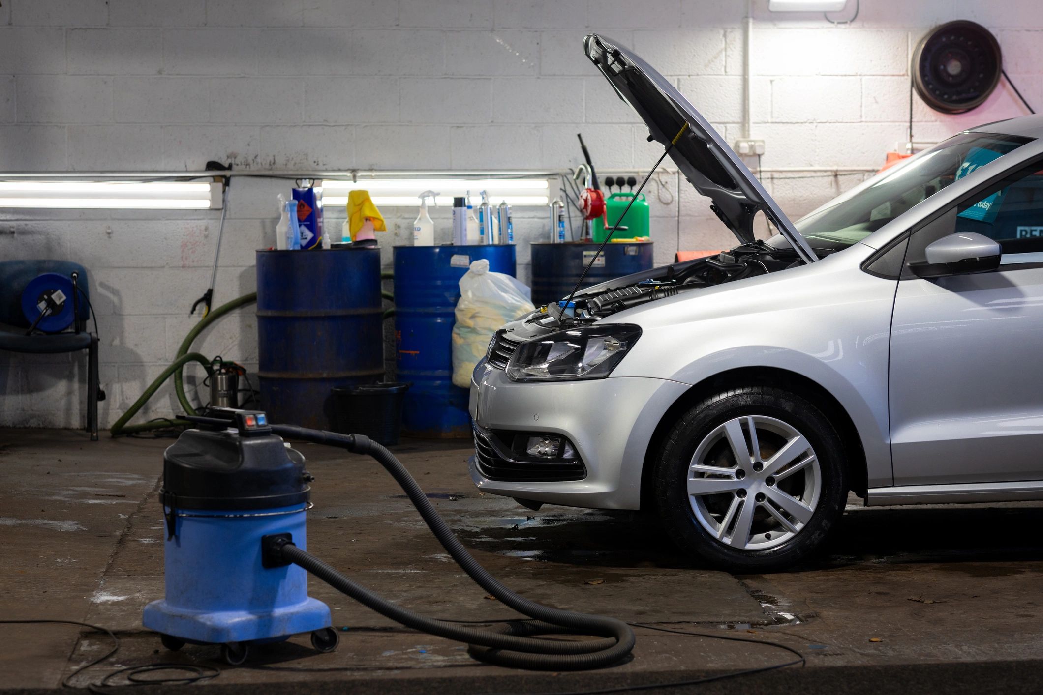 Silver car being serviced in a garage bay