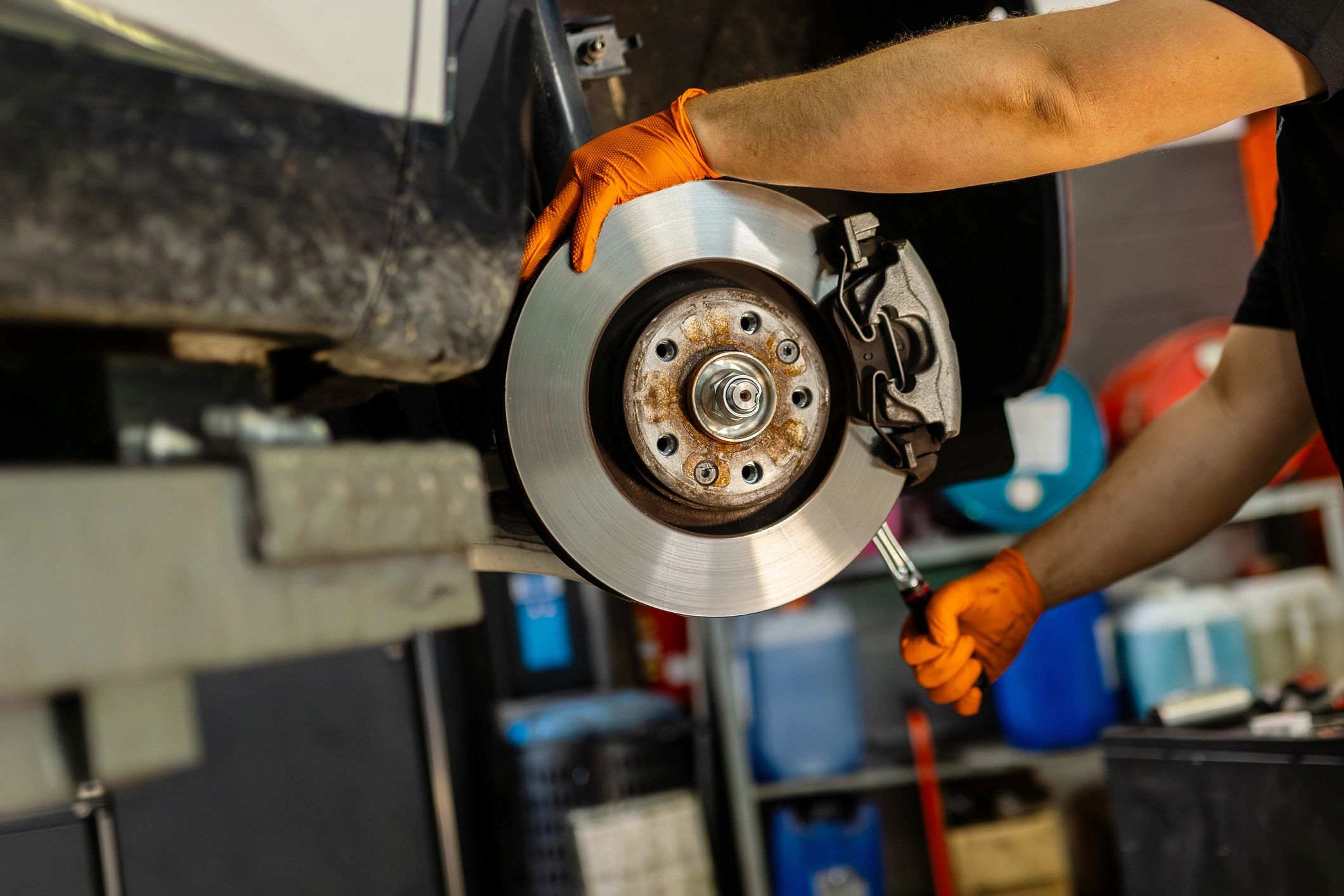 Mechanic working on car brake disc in auto workshop