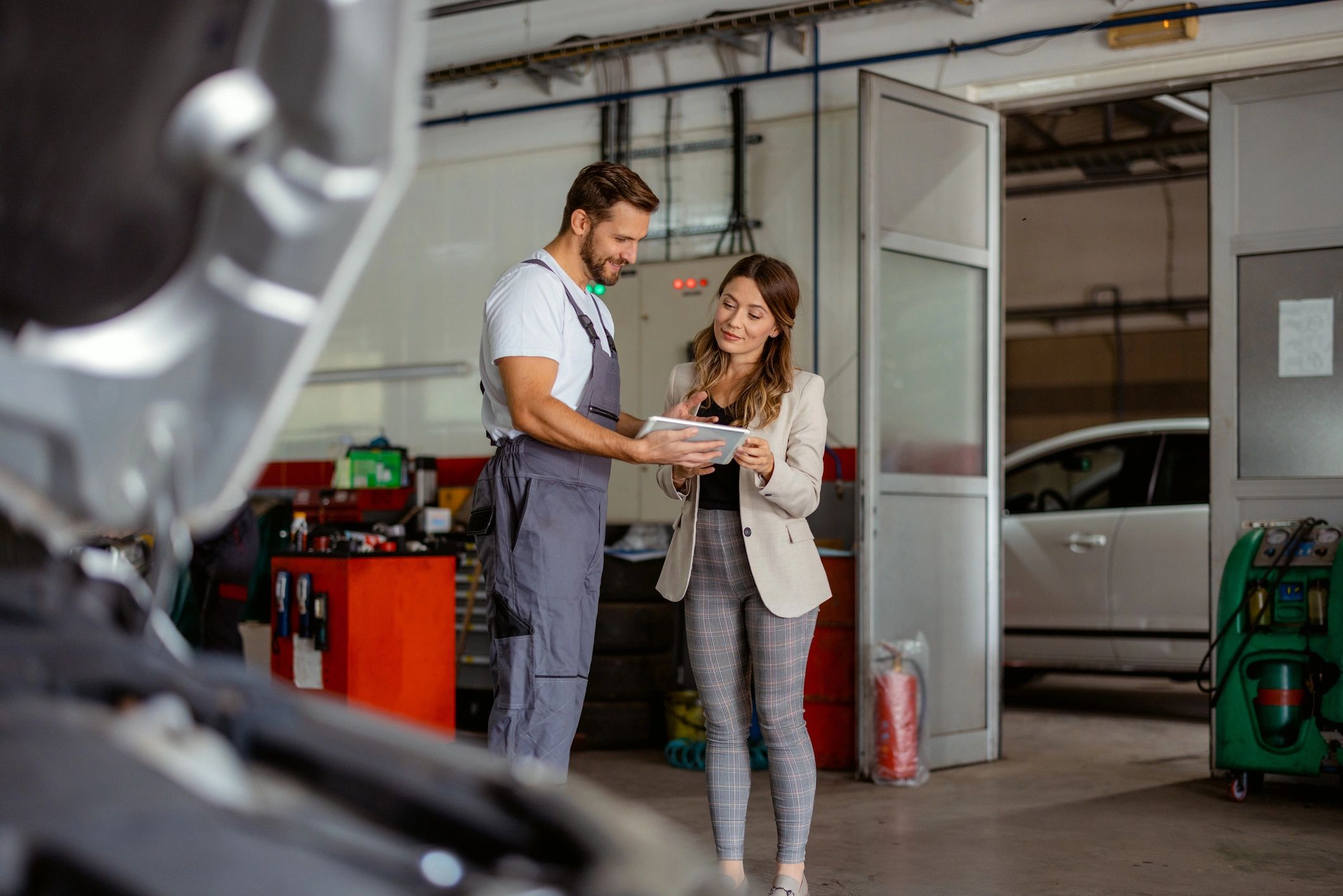 Service advisor and technician reviewing repair details on a tablet at the counter