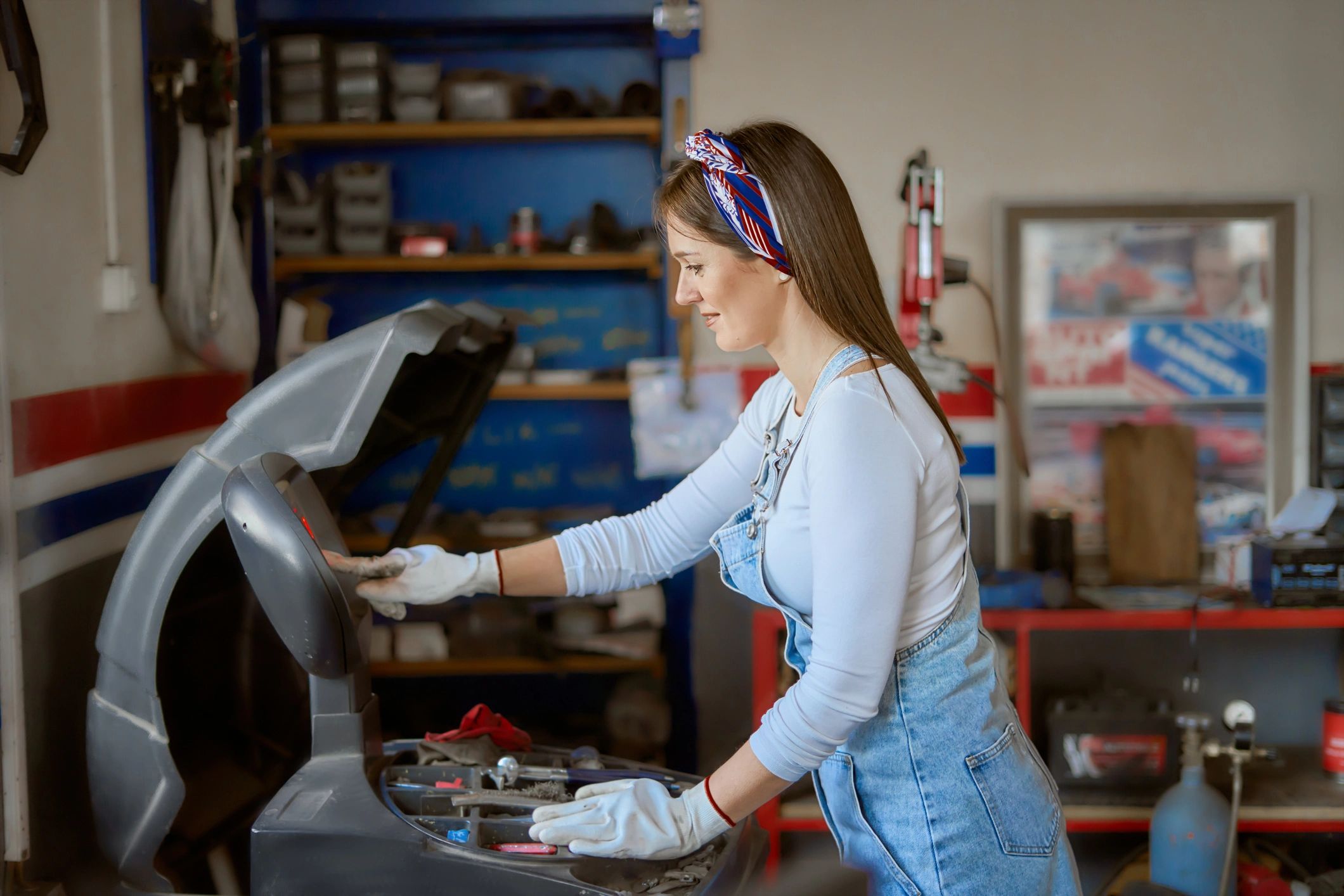 Technician working with equipment in a busy auto repair shop